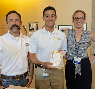 Drs. Bret McNabb and Jane Sykes present Gabe Gil (center) with his award.