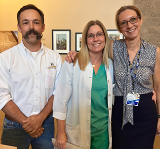 Drs. Bret McNabb and Jane Sykes present Michele Ortiz (center) with her award.