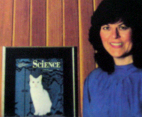 Woman next to Science magazine cover featuring a white cat